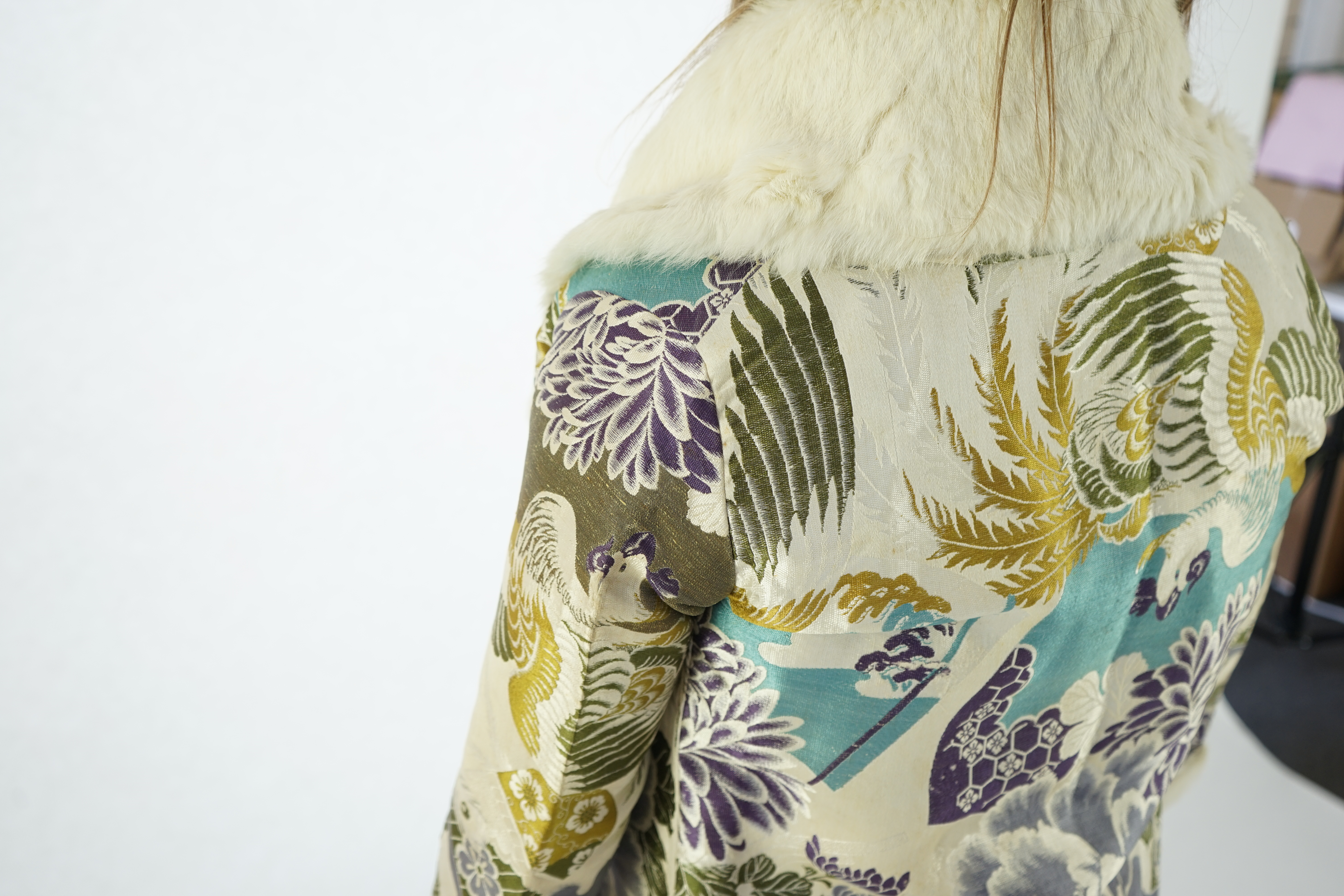 A 1940's lady's patterned brocade evening coat with white fur trim.